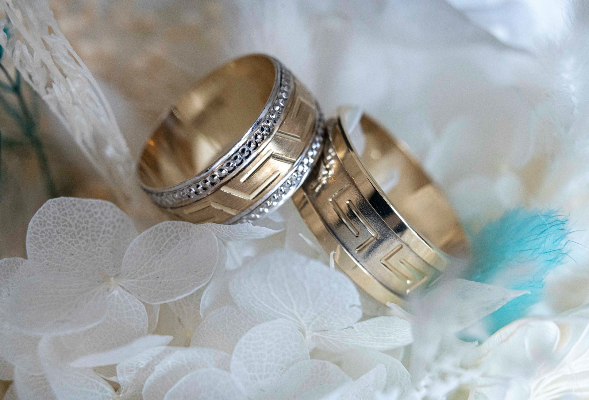 Two wedding rings sitting on top of a bouquet of flowers